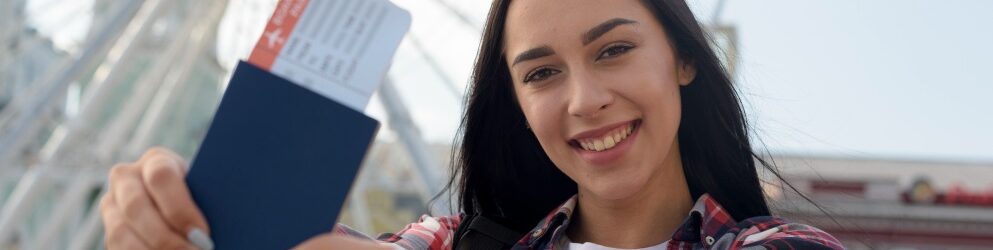 portrait-smiling-woman-showing-air-ticket-passport